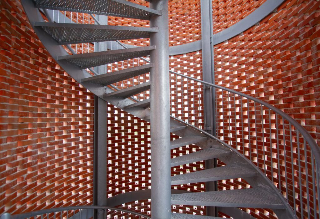 The spiral stair inside the perforated brick stair tower