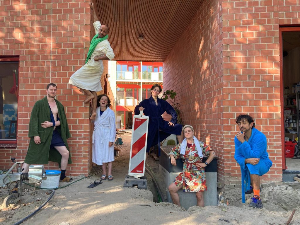 Residents posing in front of the brick facade during finishing works