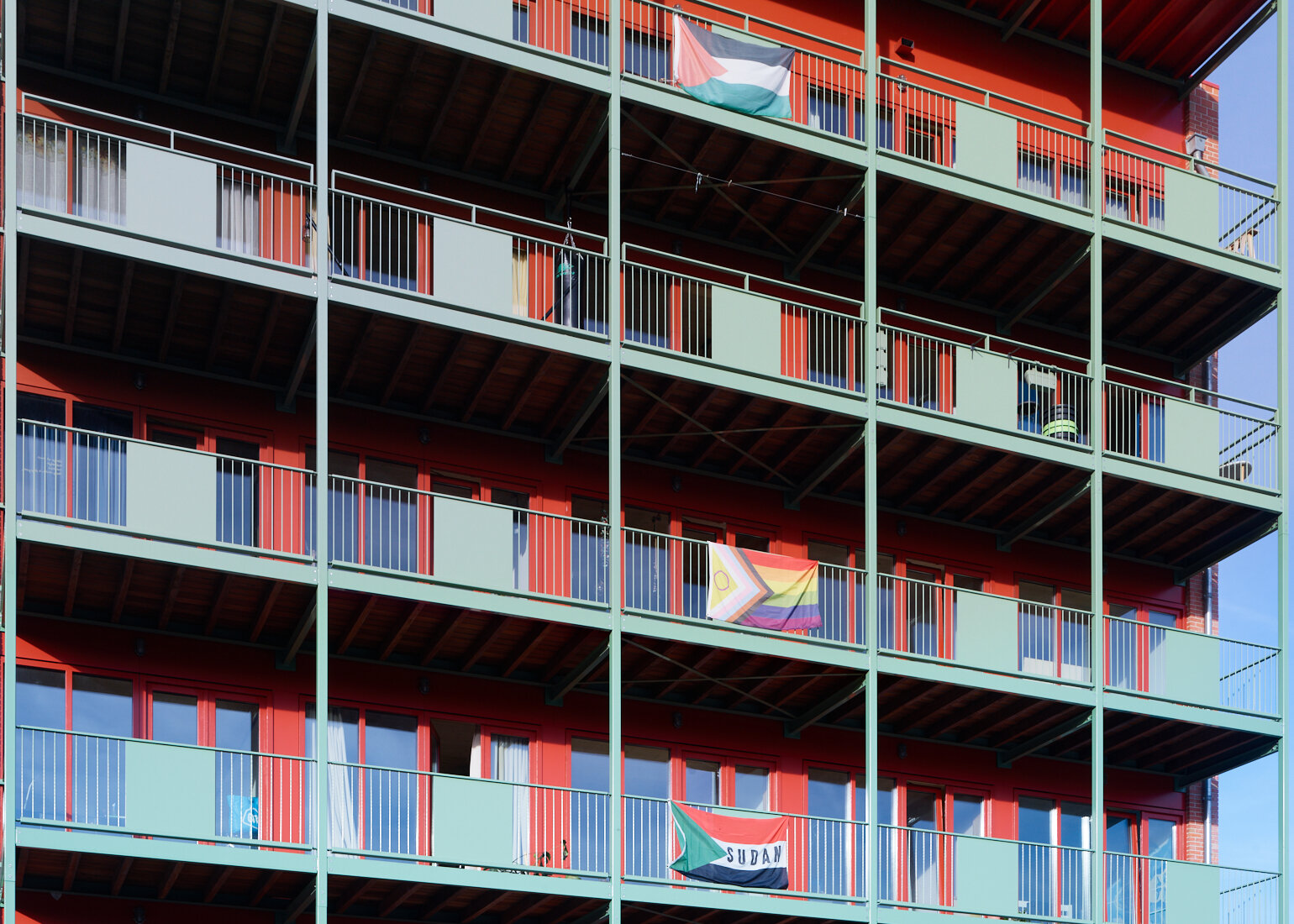 The tower’s balconies: mint-green railings in front of crimson window frames