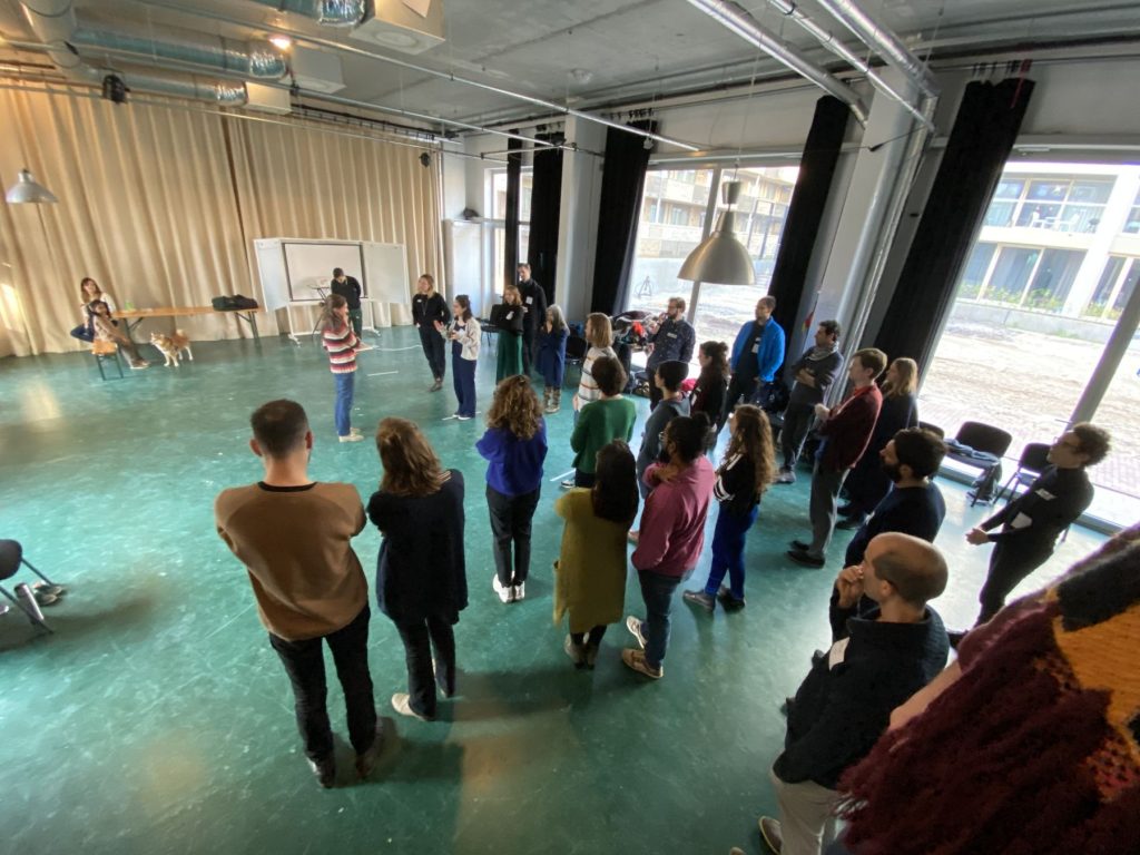 Members standing on a full-scale floor plan during a design game