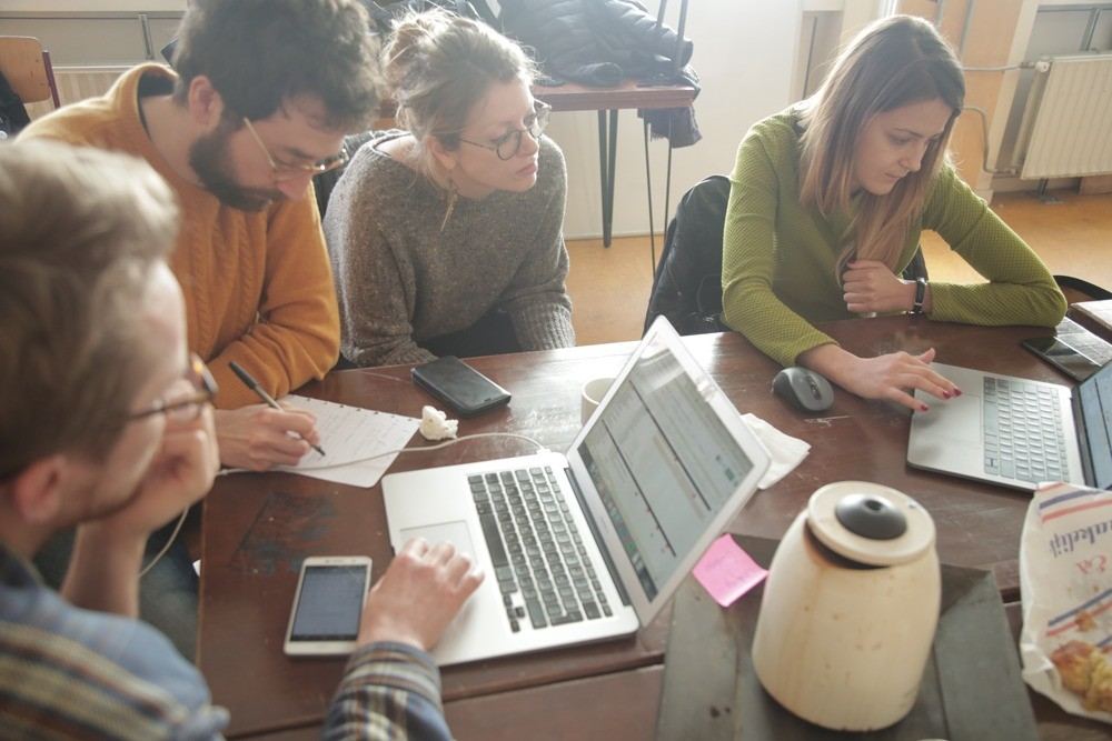 Members working together at a table with laptops