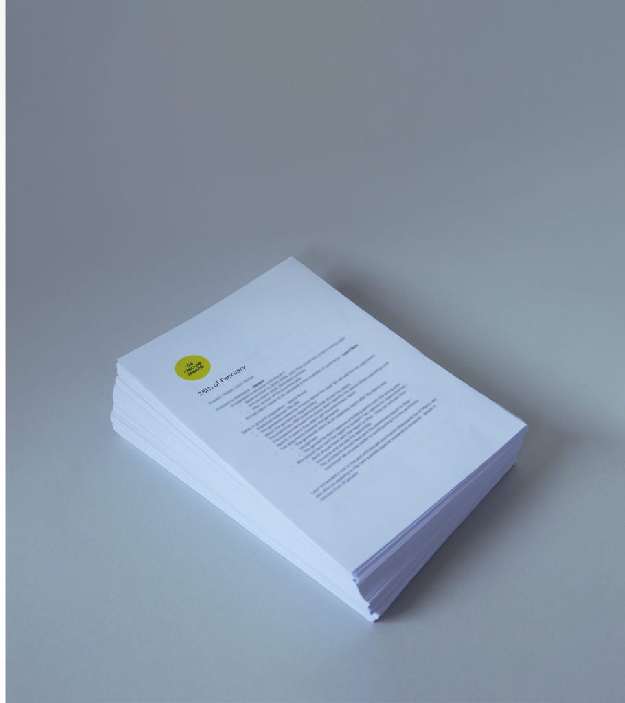 A stack of meeting minutes on a white table