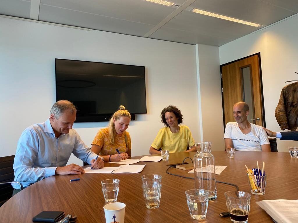 Members and bankers signing the mortgage around a meeting table